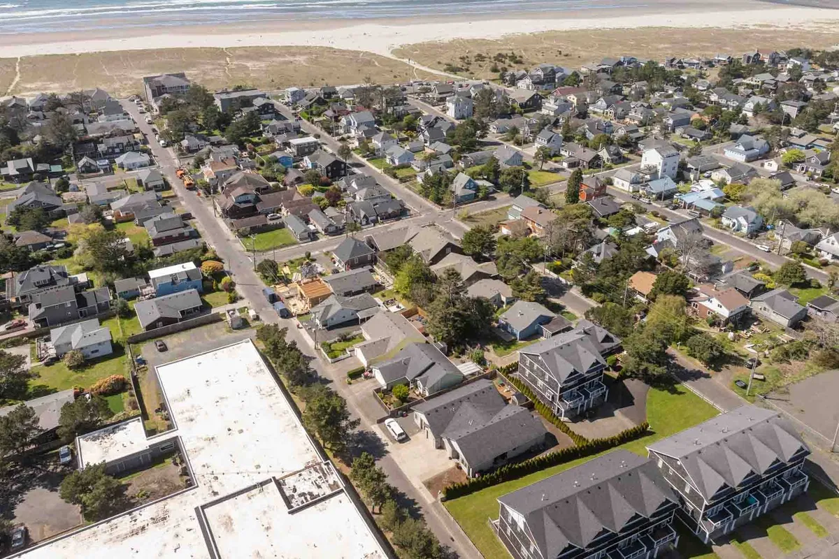 A peaceful residential exterior showing tree-lined streets and homes just steps from the sandy beach. The inviting setting highlights the community’s proximity to the shoreline and its tranquil vibe, suggesting easy access to outdoor activities and serene evenings.
