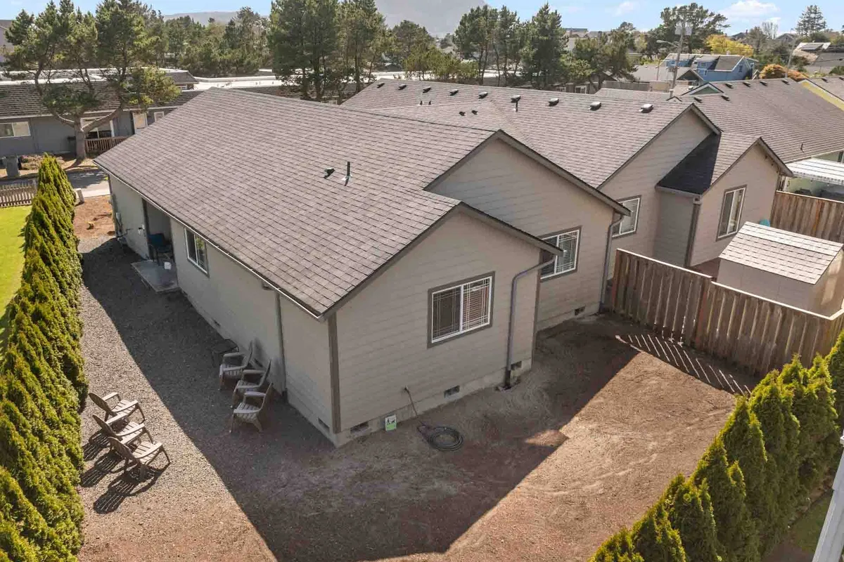 A welcoming exterior with a neatly trimmed hedge, an outdoor seating area, and a view of the building’s architecture. The area feels inviting and safe, suitable for family gatherings or pets to roam while adults relax nearby.